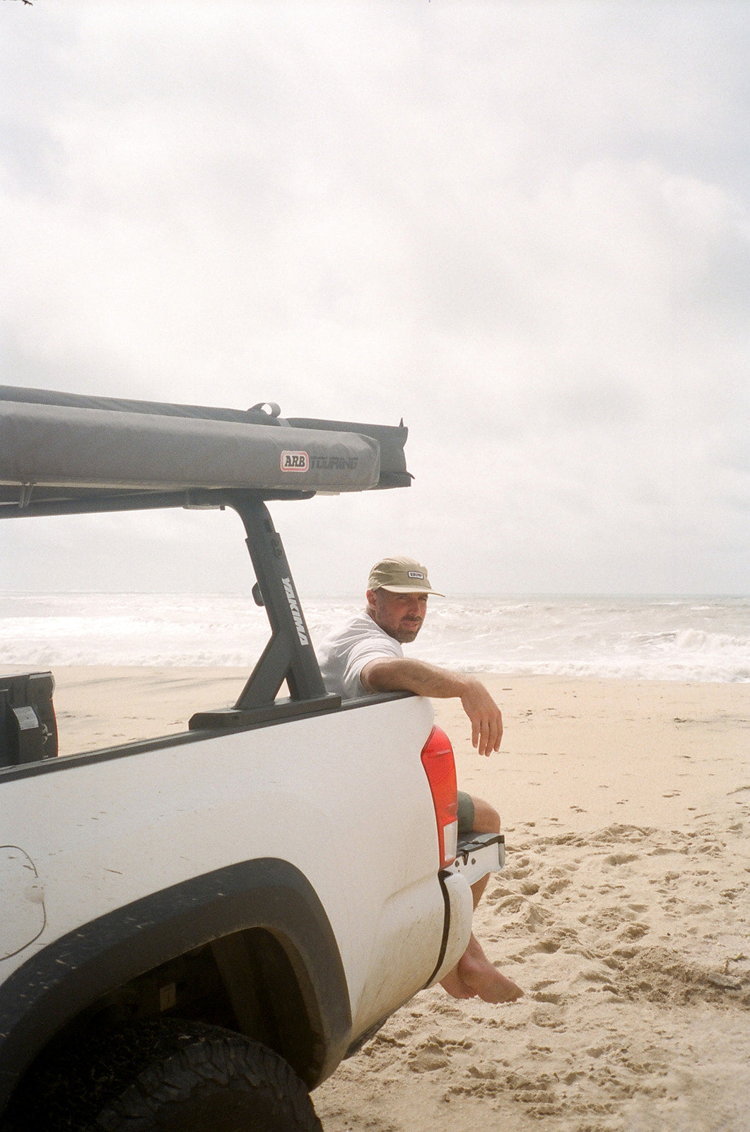 Trevor Mertens, founder of Bump Coffee, on the tailgate of his truck at the beach